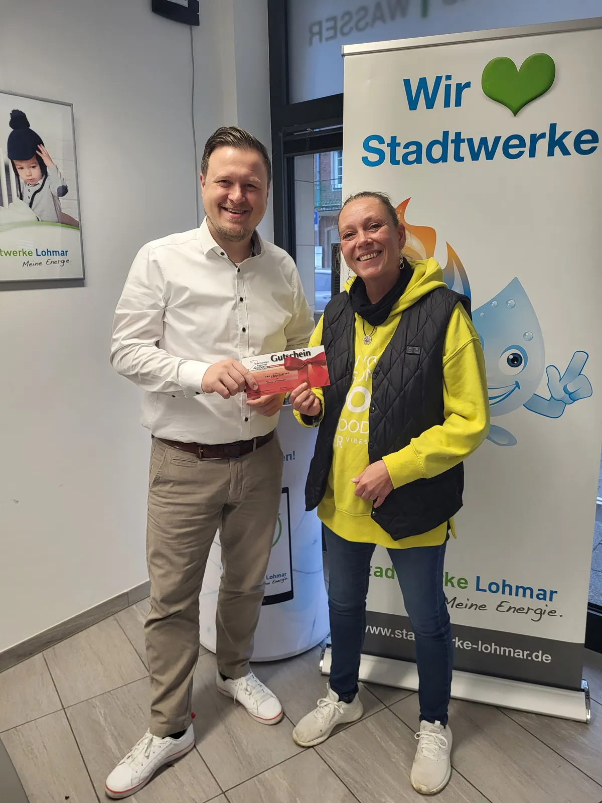 v. l. n. r.: Emanuel Laukart, Vertriebsmanager Stadtwerke Lohmar, mit Gewinnerin Tina Cramer (Foto: Stadtwerke Lohmar)  E-Bike-Gutschein an Stadtwerke-Kundin überreicht